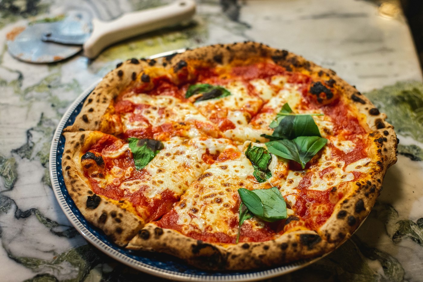 A pizza with a blistered crust and melted cheese.